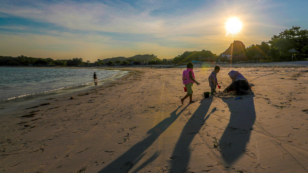 A family play’s at Tanjung Aan Beach in Lombok island Indonesia